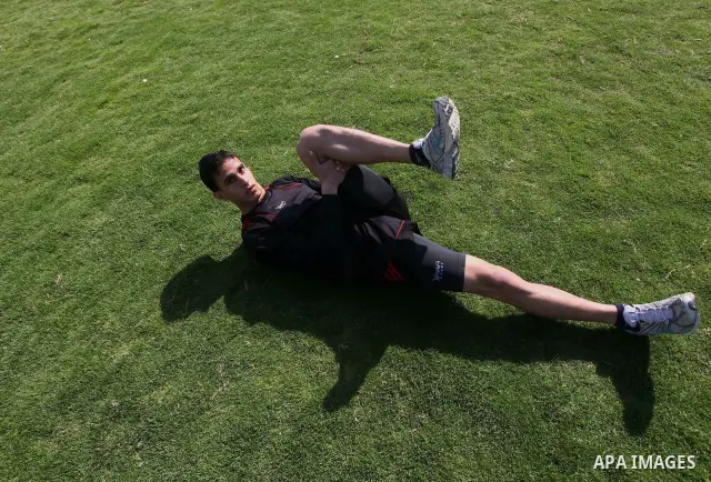 Palestinian runner Bahaa al-Farra, who has been selected to represent Palestine at the London Olympics in July - August 2012 stretches during training at the al-Yarmouk soccer stadium in Gaza City on March 29, 2012. Farr...