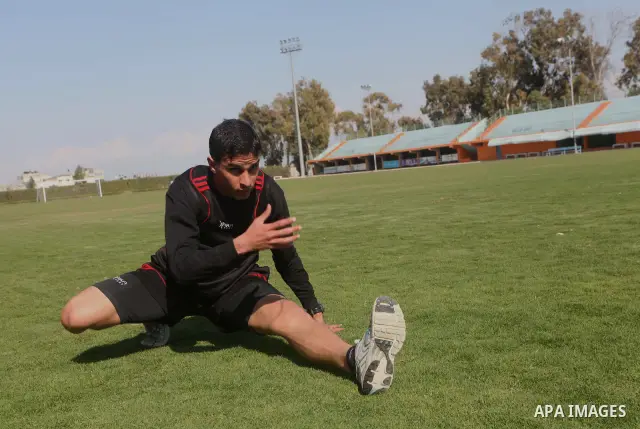 Palestinian runner Bahaa al-Farra, who has been selected to represent Palestine at the London Olympics in July - August 2012 stretches during training at the al-Yarmouk soccer stadium in Gaza City on March 29, 2012. Farr...