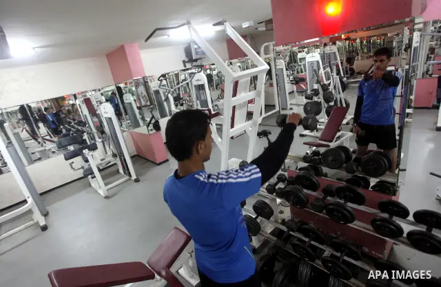 Gaza runner Bahaa al-Farra is reflected in a mirror as he trains at a gym in Gaza City March 29, 2012. The 19-year-old trains for three hours a day in Gaza's Yarmouk soccer stadium, along the dusty streets and on the bea...