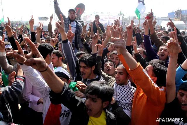 Palestinian protesters shout during a protest marking Land Day, near the border between Israel and the northern Gaza Strip March 30, 2012. Israeli security forces fired rubber bullets, tear gas and stun grenades to break...
