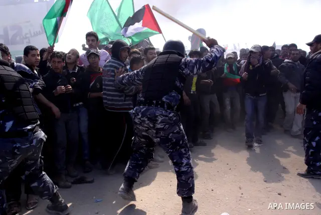 Members of Hamas security forces prevent Palestinian protesters from reaching the border between Israel and the northern Gaza Strip, after a protest marking Land Day March 30, 2012. Israeli security forces fired rubber b...