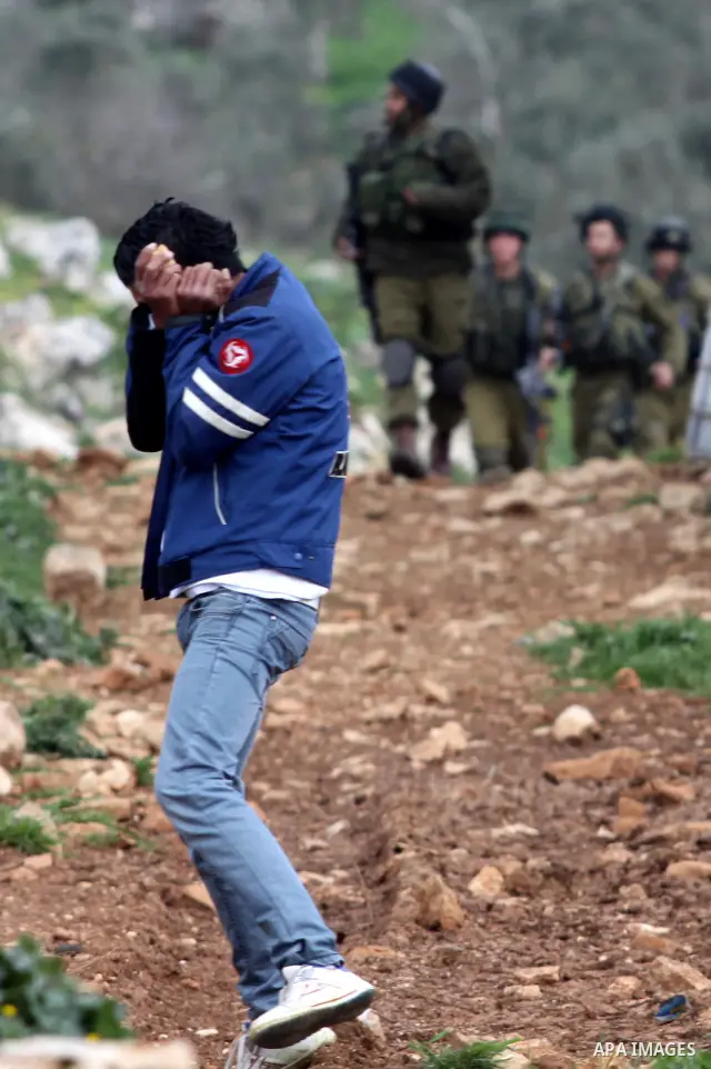 A Palestinian protester covers his face from tear gas canisters fired by Israeli soldiers during a demonstration to mark the anniversary of Land Day in the village Iraq Burin, near town of Nablus in the occupied Israeli...