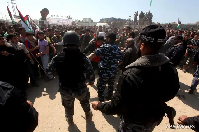Members of Hamas security forces prevent Palestinian protesters from reaching the border between Israel and the northern Gaza Strip, after a protest marking Land Day March 30, 2012. Israeli security forces fired rubber b...