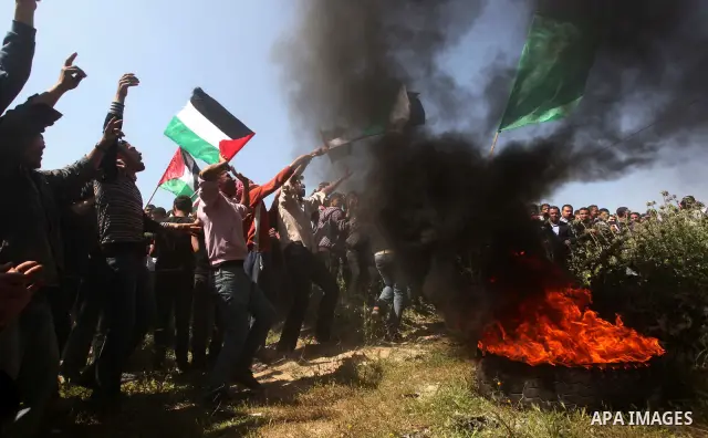 Palestinian protesters shout during a protest marking Land Day, near the border between Israel and the northern Gaza Strip March 30, 2012. Israeli security forces fired rubber bullets, tear gas and stun grenades to break...