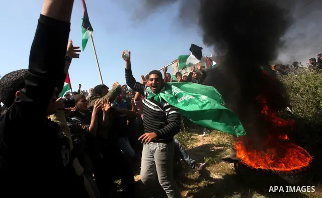 Palestinian protesters shout during a protest marking Land Day, near the border between Israel and the northern Gaza Strip March 30, 2012. Israeli security forces fired rubber bullets, tear gas and stun grenades to break...