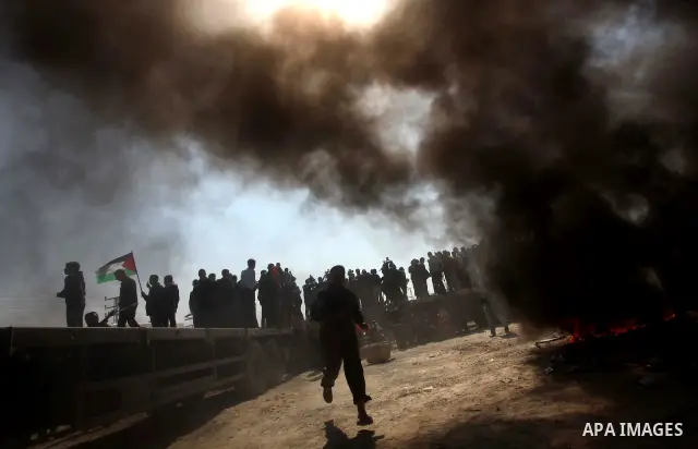 Palestinian protesters shout during a protest marking Land Day, near the border between Israel and the northern Gaza Strip March 30, 2012. Israeli security forces fired rubber bullets, tear gas and stun grenades to break...