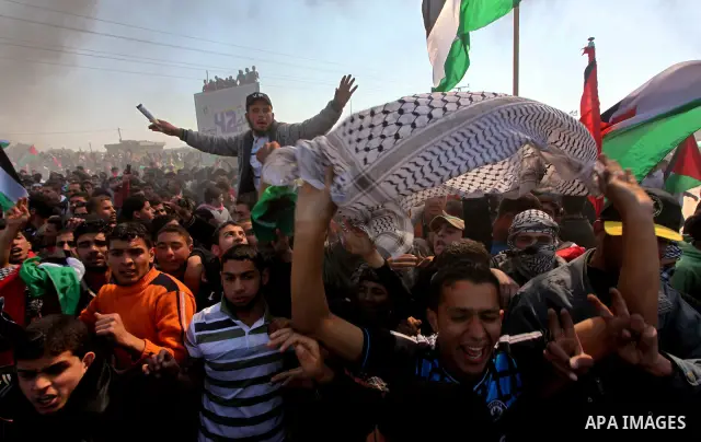 Palestinian protesters shout during a protest marking Land Day, near the border between Israel and the northern Gaza Strip March 30, 2012. Israeli security forces fired rubber bullets, tear gas and stun grenades to break...