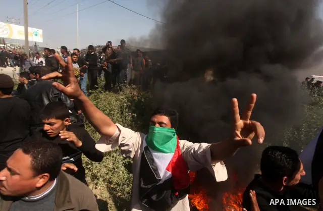 Palestinian protesters shout during a protest marking Land Day, near the border between Israel and the northern Gaza Strip March 30, 2012. Israeli security forces fired rubber bullets, tear gas and stun grenades to break...