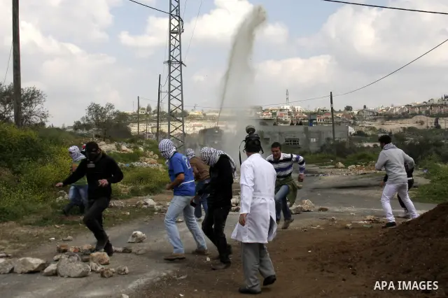 Palestinian protesters throw stones at Israeli soldiers during a demonstration to mark the anniversary of Land Day in the village Kafr Qaddum, close to the northern town of Nablus in the occupied Israeli West bank on Mar...
