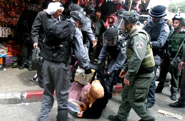 Israeli border police officers detain a woman during clashes on Land Day after Friday prayers outside Damascus Gate in Jerusalem's Old City March 30, 2012. Israeli security forces fired rubber bullets, tear gas and stun...