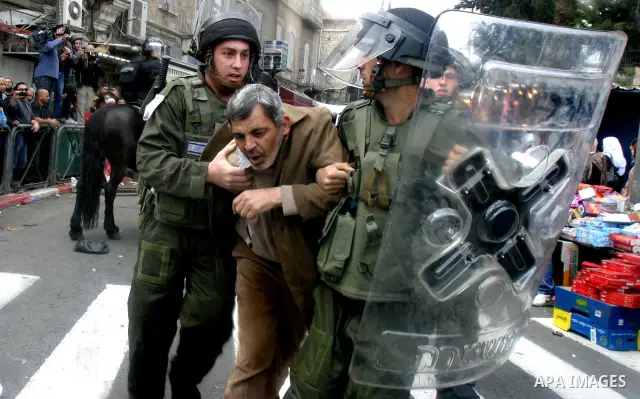 Israeli border police officers detain a Palestinian protester during clashes on Land Day after Friday prayers outside Damascus Gate in Jerusalem's Old City March 30, 2012. Israeli security forces fired rubber bullets, te...