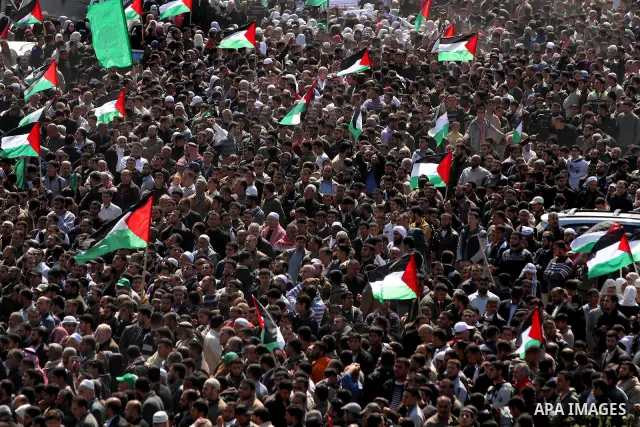 Palestinian protesters hold up their national flag as they protest close to the border between Israel and the northern Gaza Strip, during Land Day demonstrations in Beit Hanun, on March 30, 2012. Rallies were held across...