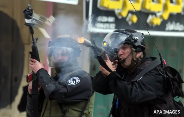 Israeli troops fire teargas at protesters during clashes at Kalandia checkpoint between Jerusalem and the West Bank city of Ramallah, Friday, March 30, 2012. Israeli security forces in riot gear Friday confronted Palesti...
