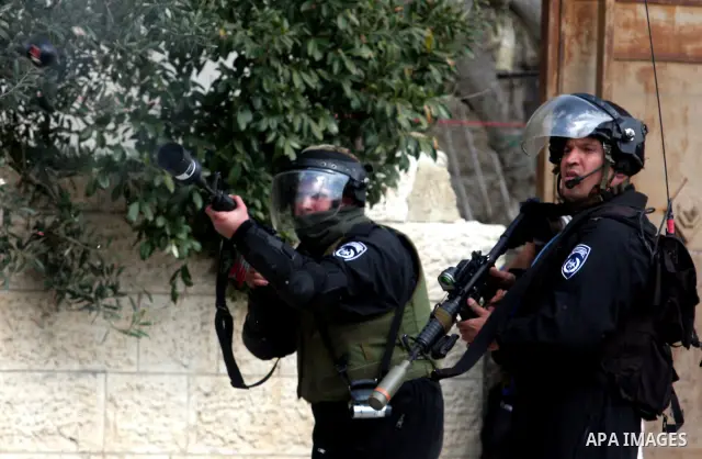 Israeli troops fire teargas at protesters during clashes at Kalandia checkpoint between Jerusalem and the West Bank city of Ramallah, Friday, March 30, 2012. Israeli security forces in riot gear Friday confronted Palesti...