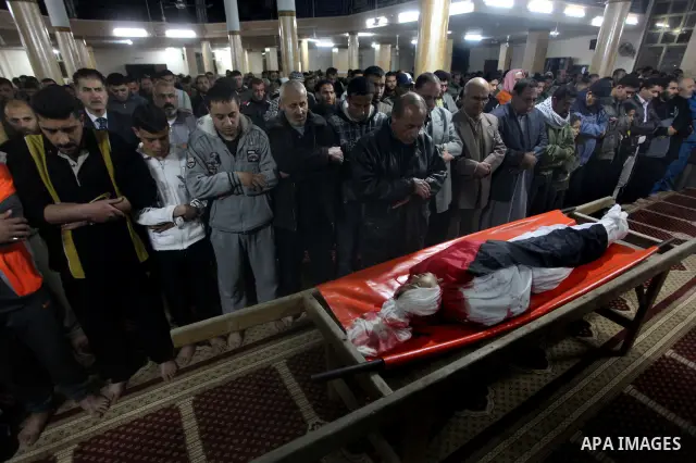Palestinian mourners pray next to the body of Mahmoud Zakot, 20, during his funeral in the northern Gaza Strip March 30, 2012. Israeli security forces shot dead Zakot in the Gaza Strip on Friday, medics said, and clashed...