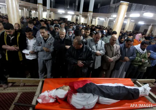 Palestinian mourners pray next to the body of Mahmoud Zakot, 20, during his funeral in the northern Gaza Strip March 30, 2012. Israeli security forces shot dead Zakot in the Gaza Strip on Friday, medics said, and clashed...
