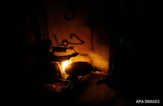 Palestinians prepare freshly baked pita bread at a traditional bakery using a wood burning stove in the Rafah refugee camp in the southern Gaza Strip on March 31, 2012. Gaza is experiencing a major electricity crisis bec...