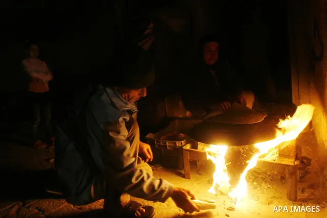 Palestinians prepare freshly baked pita bread at a traditional bakery using a wood burning stove in the Rafah refugee camp in the southern Gaza Strip on March 31, 2012. Gaza is experiencing a major electricity crisis bec...