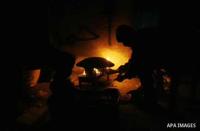 Palestinians prepare freshly baked pita bread at a traditional bakery using a wood burning stove in the Rafah refugee camp in the southern Gaza Strip on March 31, 2012. Gaza is experiencing a major electricity crisis bec...