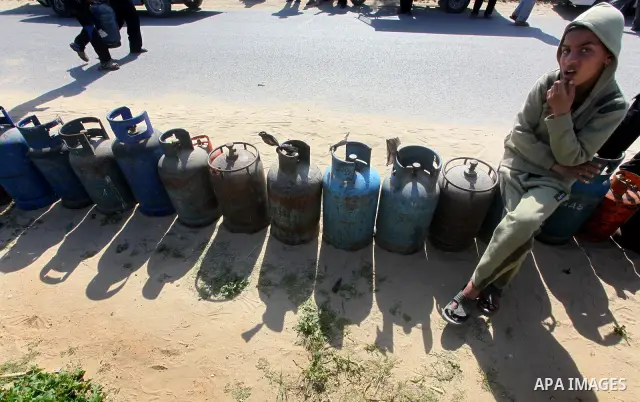 Palestinians wait to fill canisters with cooking gas outside a filling station in Deir al-Balah, in the central Gaza Strip, April 1, 2012. Palestinians in the Gaza Strip are experiencing shortage in gas and fuel. Photo b...