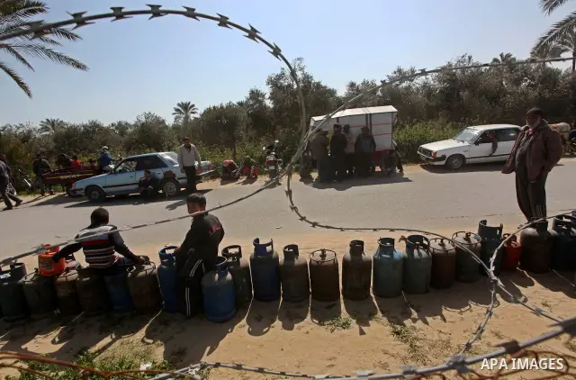 Palestinians wait to fill canisters with cooking gas outside a filling station in Deir al-Balah, in the central Gaza Strip, April 1, 2012. Palestinians in the Gaza Strip are experiencing shortage in gas and fuel. Photo b...