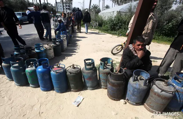 Palestinians wait to fill canisters with cooking gas outside a filling station in Deir al-Balah, in the central Gaza Strip, April 1, 2012. Palestinians in the Gaza Strip are experiencing shortage in gas and fuel. Photo b...