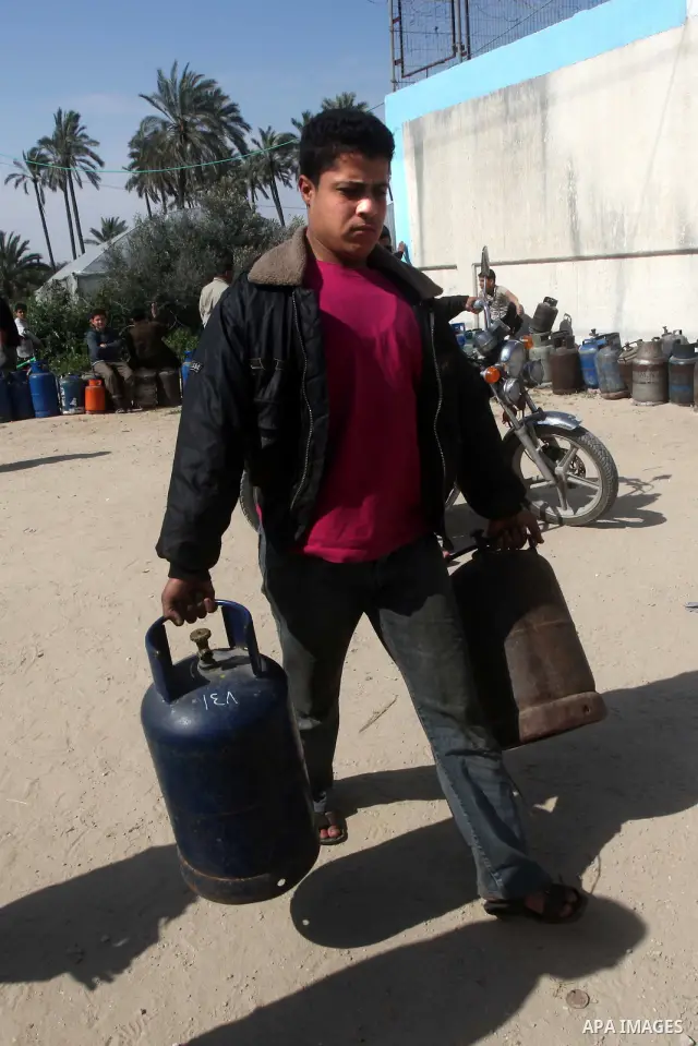 Palestinians wait to fill canisters with cooking gas outside a filling station in Deir al-Balah, in the central Gaza Strip, April 1, 2012. Palestinians in the Gaza Strip are experiencing shortage in gas and fuel. Photo b...