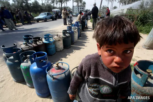 Palestinians wait to fill canisters with cooking gas outside a filling station in Deir al-Balah, in the central Gaza Strip, April 1, 2012. Palestinians in the Gaza Strip are experiencing shortage in gas and fuel. Photo b...