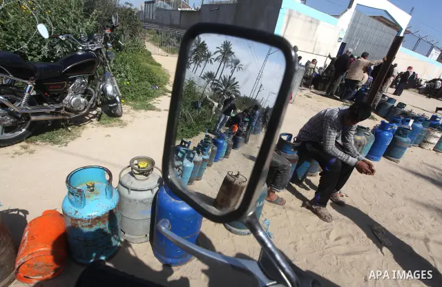 Palestinians wait to fill canisters with cooking gas outside a filling station in Deir al-Balah, in the central Gaza Strip, April 1, 2012. Palestinians in the Gaza Strip are experiencing shortage in gas and fuel. Photo b...