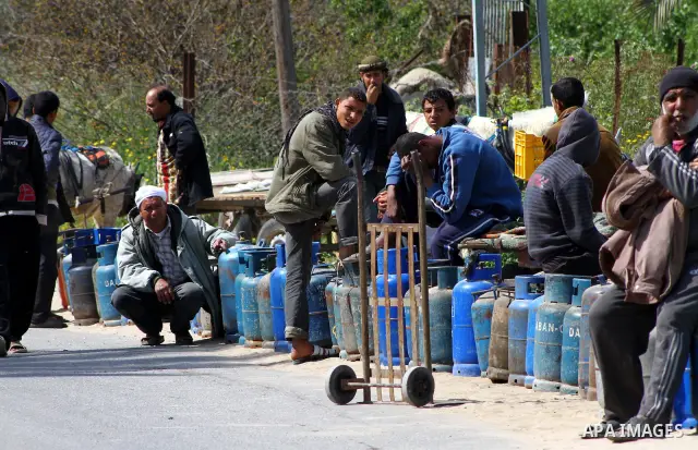 Palestinians wait to fill canisters with cooking gas outside a filling station in Deir al-Balah, in the central Gaza Strip, April 1, 2012. Palestinians in the Gaza Strip are experiencing shortage in gas and fuel. Photo b...