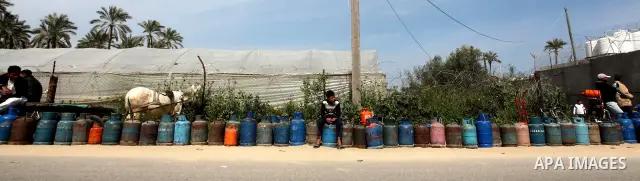 Palestinians wait to fill canisters with cooking gas outside a filling station in Deir al-Balah, in the central Gaza Strip, April 1, 2012. Palestinians in the Gaza Strip are experiencing shortage in gas and fuel. Photo b...