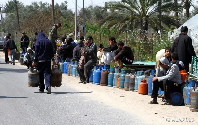 Palestinians wait to fill canisters with cooking gas outside a filling station in Deir al-Balah, in the central Gaza Strip, April 1, 2012. Palestinians in the Gaza Strip are experiencing shortage in gas and fuel. Photo b...