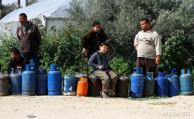Palestinians wait to fill canisters with cooking gas outside a filling station in Deir al-Balah, in the central Gaza Strip, April 1, 2012. Palestinians in the Gaza Strip are experiencing shortage in gas and fuel. Photo b...