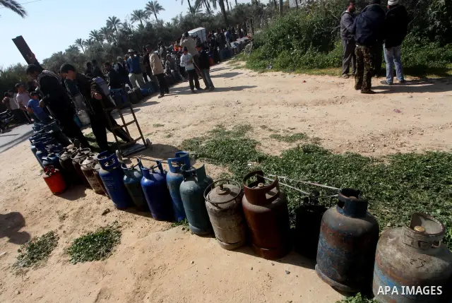 Palestinians wait to fill canisters with cooking gas outside a filling station in Deir al-Balah, in the central Gaza Strip, April 1, 2012. Palestinians in the Gaza Strip are experiencing shortage in gas and fuel. Photo b...