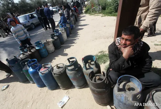 Palestinians wait to fill canisters with cooking gas outside a filling station in Deir al-Balah, in the central Gaza Strip, April 1, 2012. Palestinians in the Gaza Strip are experiencing shortage in gas and fuel. Photo b...