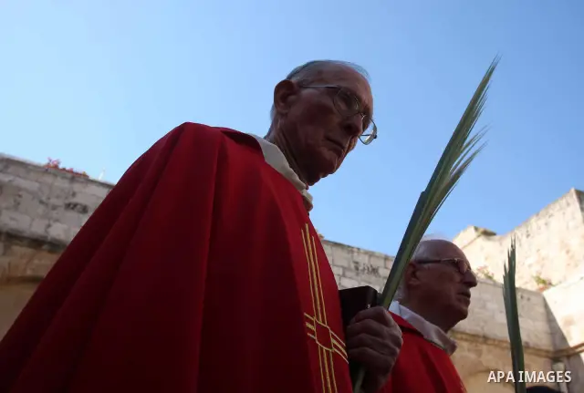 Palestinians Catholic attend a Palm Sunday at a church "Nativity" in Bethlehem in the West Bank in, Sunday, April 1, 2012. Palm Sunday commemorates Jesus Christ's triumphant entry into Jerusalem when his followers laid p...