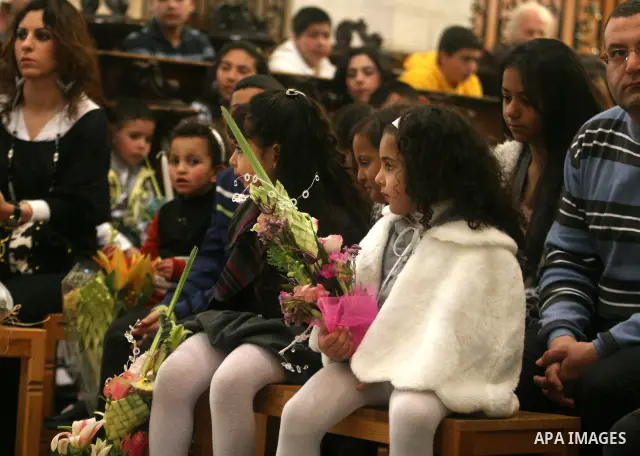 Palestinians Catholic attend a Palm Sunday at a church "Nativity" in Bethlehem in the West Bank in, Sunday, April 1, 2012. Palm Sunday commemorates Jesus Christ's triumphant entry into Jerusalem when his followers laid p...