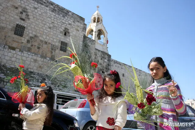 Palestinians Catholic attend a Palm Sunday at a church "Nativity" in Bethlehem in the West Bank in, Sunday, April 1, 2012. Palm Sunday commemorates Jesus Christ's triumphant entry into Jerusalem when his followers laid p...