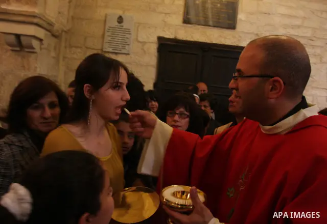 Palestinians Catholic attend a Palm Sunday at a church "Nativity" in Bethlehem in the West Bank in, Sunday, April 1, 2012. Palm Sunday commemorates Jesus Christ's triumphant entry into Jerusalem when his followers laid p...