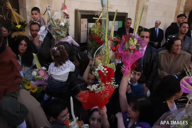 Palestinians Catholic attend a Palm Sunday at a church "Nativity" in Bethlehem in the West Bank in, Sunday, April 1, 2012. Palm Sunday commemorates Jesus Christ's triumphant entry into Jerusalem when his followers laid p...