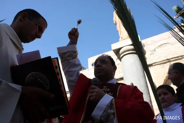 Palestinians Catholic attend a Palm Sunday at a church "Nativity" in Bethlehem in the West Bank in, Sunday, April 1, 2012. Palm Sunday commemorates Jesus Christ's triumphant entry into Jerusalem when his followers laid p...