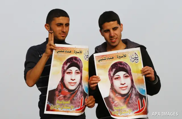 Palestinians hold posters of Hanaa Shalabi, a prisoner who spent 43 days on hunger strike, as they wait to greet her near the Erez border crossing between Israel and the northern Gaza Strip on April 1, 2012. Shalabi, who...