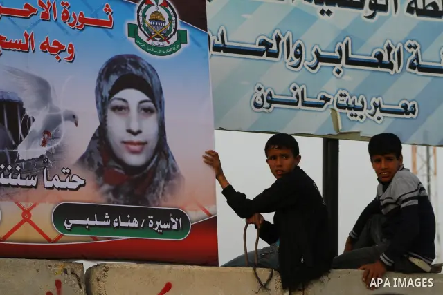 Palestinians hold posters of Hanaa Shalabi, a prisoner who spent 43 days on hunger strike, as they wait to greet her near the Erez border crossing between Israel and the northern Gaza Strip on April 1, 2012. Shalabi, who...