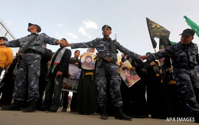 Palestinians hold posters of Hanaa Shalabi, a prisoner who spent 43 days on hunger strike, as they wait to greet her near the Erez border crossing between Israel and the northern Gaza Strip on April 1, 2012. Shalabi, who...