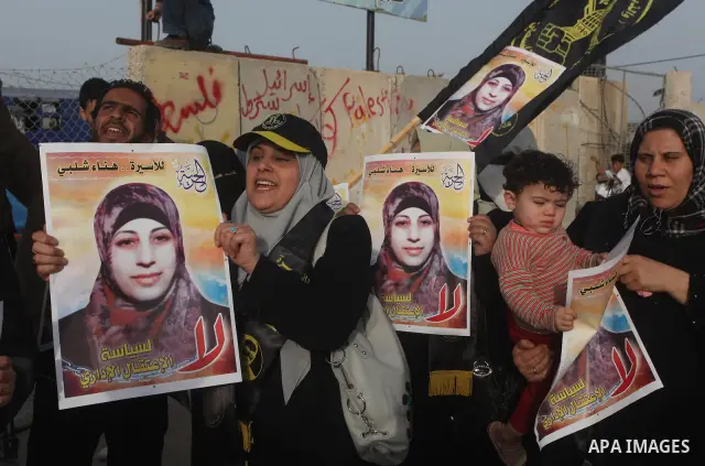 Palestinians hold posters of Hanaa Shalabi, a prisoner who spent 43 days on hunger strike, as they wait to greet her near the Erez border crossing between Israel and the northern Gaza Strip on April 1, 2012. Shalabi, who...