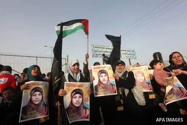 Palestinians hold posters of Hanaa Shalabi, a prisoner who spent 43 days on hunger strike, as they wait to greet her near the Erez border crossing between Israel and the northern Gaza Strip on April 1, 2012. Shalabi, who...