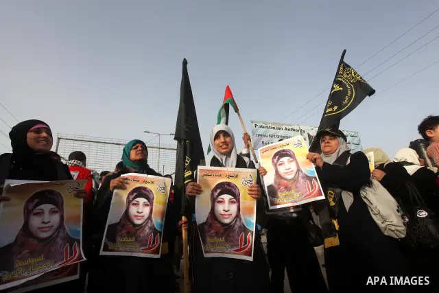 Palestinians hold posters of Hanaa Shalabi, a prisoner who spent 43 days on hunger strike, as they wait to greet her near the Erez border crossing between Israel and the northern Gaza Strip on April 1, 2012. Shalabi, who...