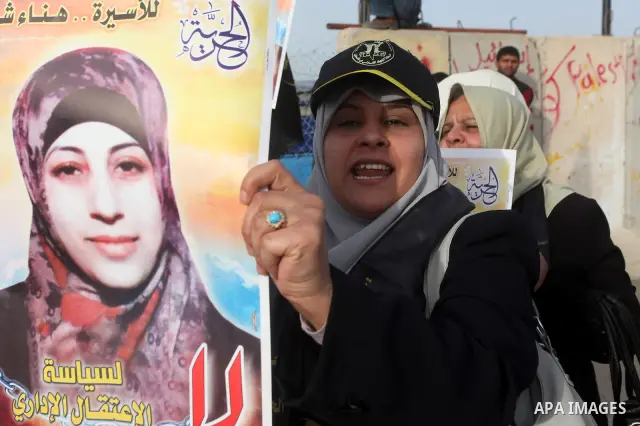 Palestinians hold posters of Hanaa Shalabi, a prisoner who spent 43 days on hunger strike, as they wait to greet her near the Erez border crossing between Israel and the northern Gaza Strip on April 1, 2012. Shalabi, who...