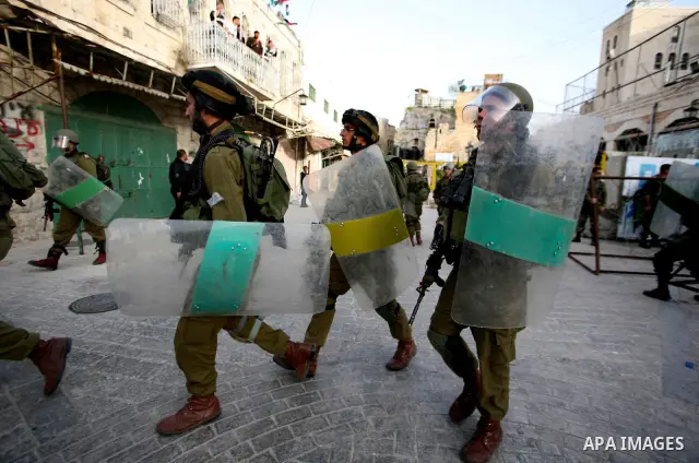 Israeli soldiers enter an abandoned house on April 01, 2012, where Palestinian protesters and foreign activists took refuge and fly Palestinian flags on the building near the Beit Romano area that several hundred Jewish...