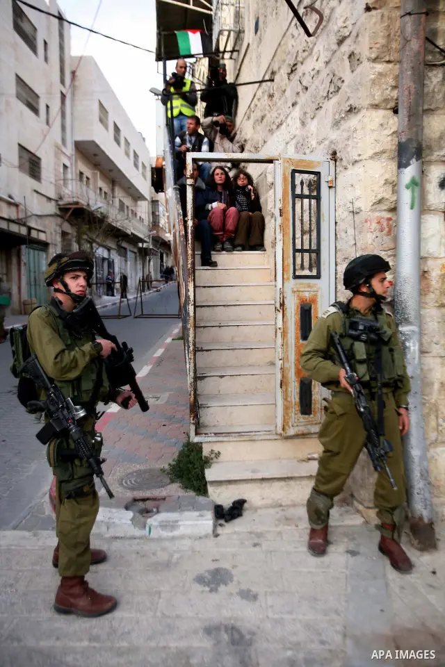 Israeli soldiers enter an abandoned house on April 01, 2012, where Palestinian protesters and foreign activists took refuge and fly Palestinian flags on the building near the Beit Romano area that several hundred Jewish...